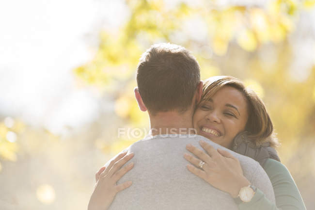 Entusiasta pareja abrazándose al aire libre - foto de stock