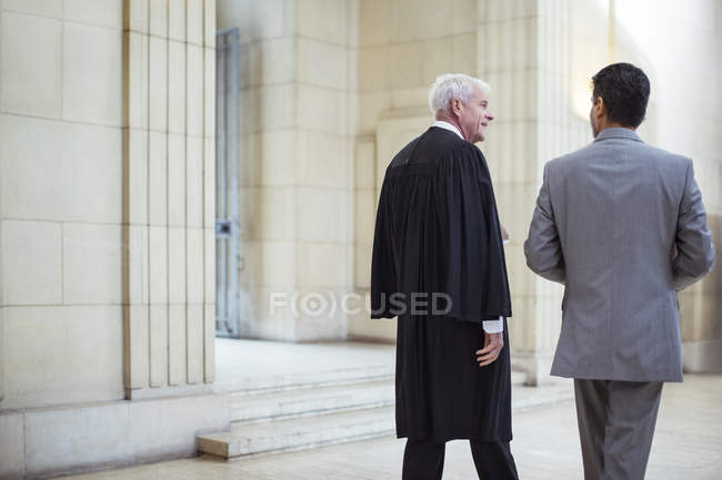 Juez y abogado caminando juntos por el juzgado - foto de stock