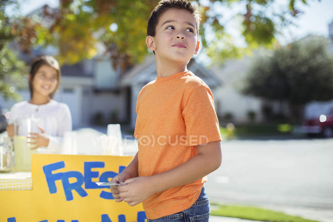 Хлопчик купує лимонад на підставці для лимонаду — стокове фото