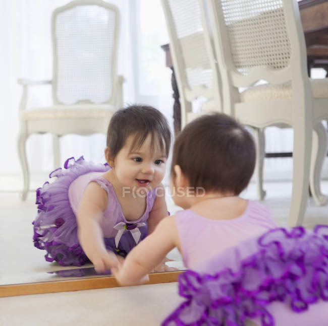 Дитяча дівчинка захоплюється собою у дзеркалі — стокове фото