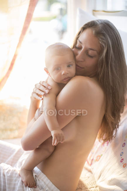 Desnudo pecho madre sosteniendo bebé niño - foto de stock