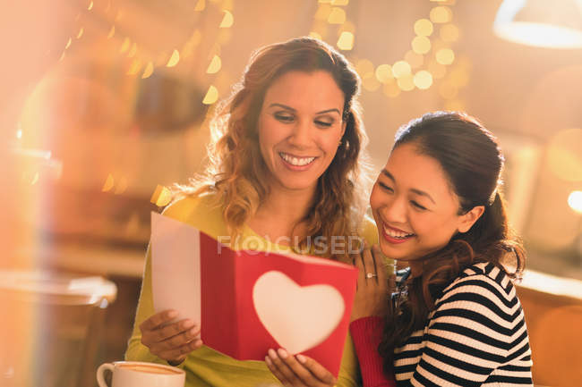 Affectionate lesbian couple with Valentines Day card — Stock Photo