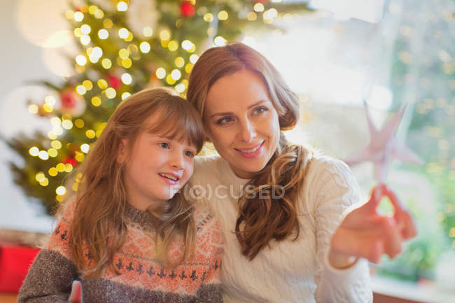 Мати і дочка, дивлячись на різдвяну зірку — стокове фото