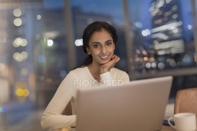 Femme d'affaires travaillant tard à l'ordinateur portable dans le bureau la nuit — Photo de stock