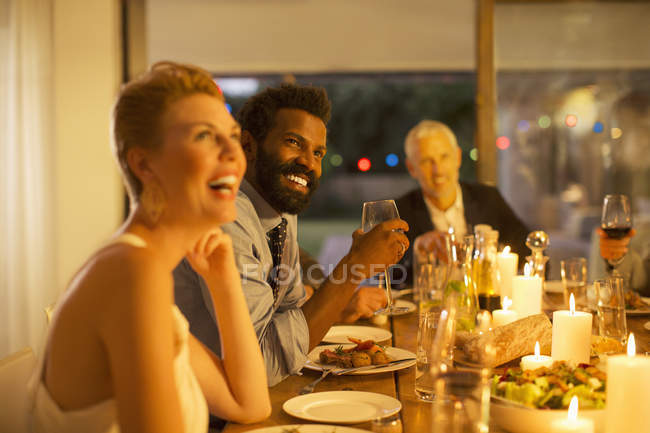 Amigos riéndose en la cena - foto de stock
