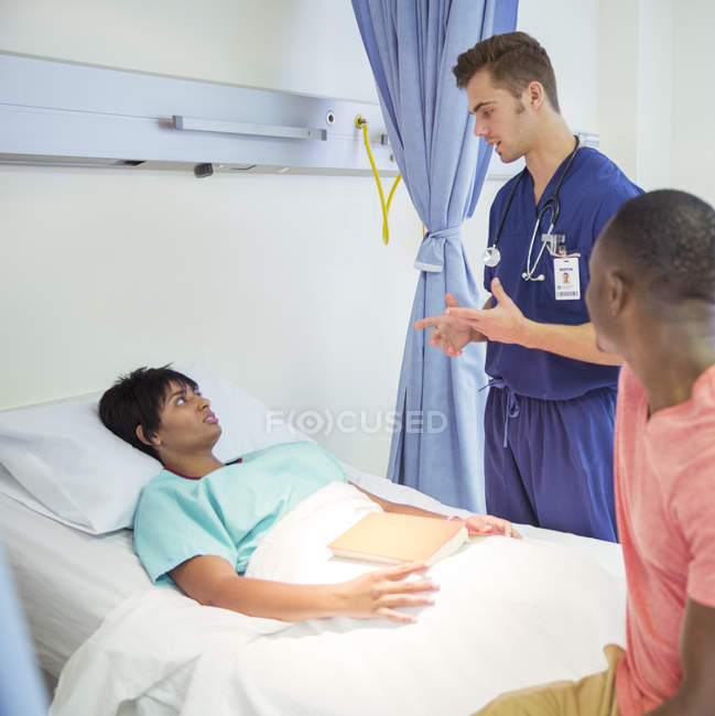 Медсестра розмовляє з пацієнтом у лікарняній кімнаті — стокове фото