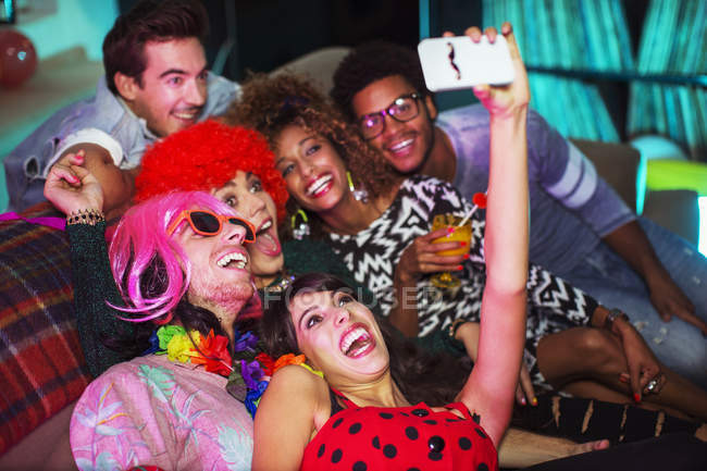 Gruppo di amici che si fanno selfie sul divano alla festa — Foto stock