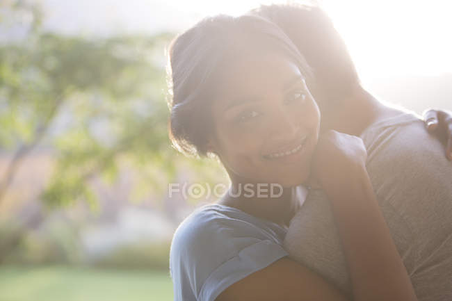 Portrait smiling woman hugging man outdoors — Stock Photo