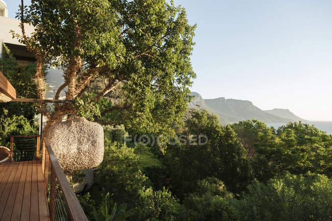 Vista panorâmica das montanhas através de árvores fora da varanda — Fotografia de Stock