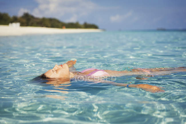 Mulher serena flutuando no oceano tropical — Fotografia de Stock