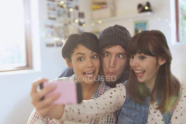 Jovens amigos brincalhões tirando selfie fazendo caras bobas — Fotografia de Stock