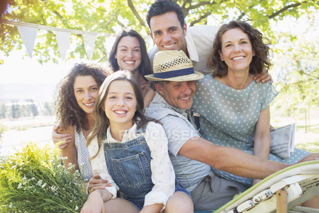 Щаслива сучасна сім'я обіймається на відкритому повітрі на пікніку — стокове фото