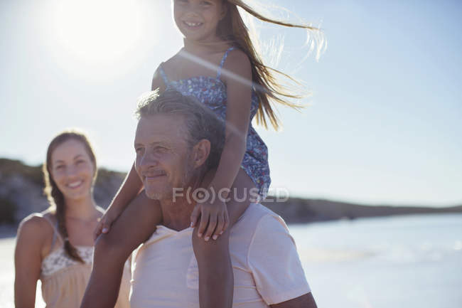 Vater hält Tochter am Strand auf Schultern — Stockfoto