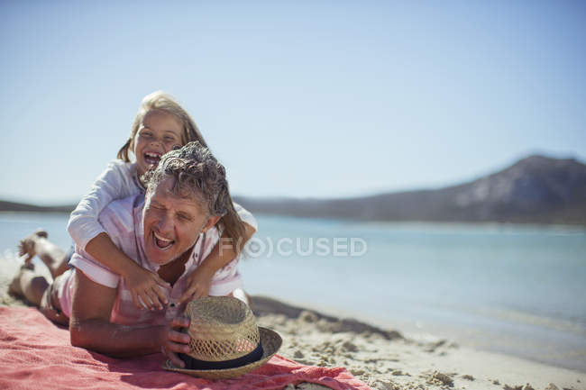 Grandfather and granddaughter playing on beach — Stock Photo