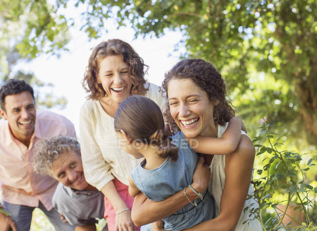 Familia caucásica feliz jugando con los demás al aire libre - foto de stock