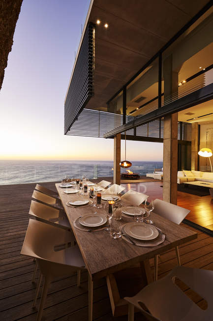 Table à manger moderne de luxe avec vue sur l'océan coucher de soleil — Photo de stock