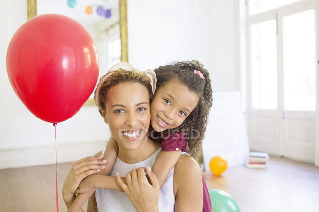 Mother and daughter hugging in living space — Stock Photo