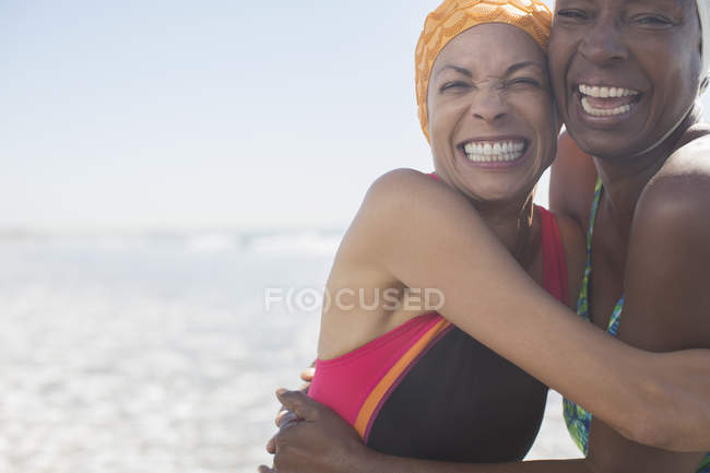 Mulheres idosas entusiasmadas abraçando na praia — Fotografia de Stock