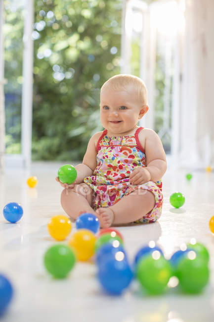 Baby girl playing with toys on floor — Stock Photo