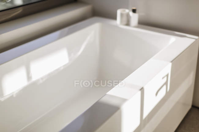 Réflexion ensoleillée sur la baignoire blanche moderne — Photo de stock