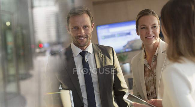 Retrato sonriente hombre de negocios con mujeres de negocios en el cargo - foto de stock
