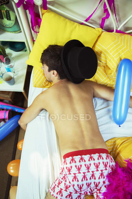 Homem dormindo na cama após a festa — Fotografia de Stock