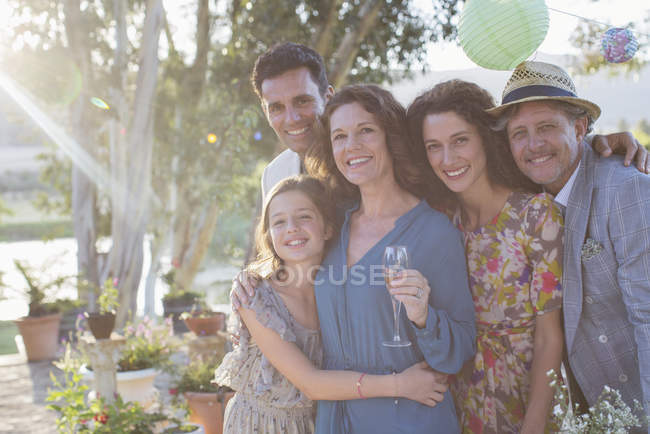 Family hugging outdoors on sunny day — Stock Photo