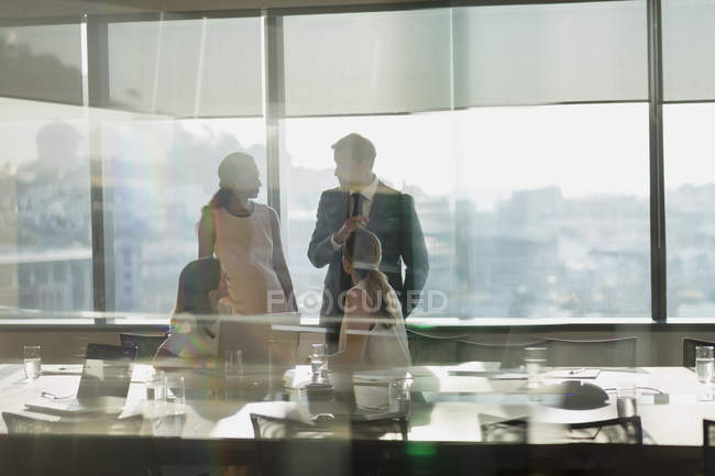 Geschäftsleute unterhalten sich in sonnigen, städtischen Konferenzräumen — Stockfoto