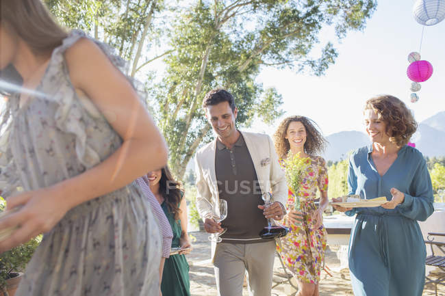Happy modern family moving dishes from table outdoors — Stock Photo