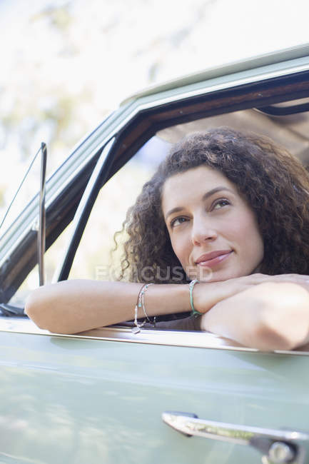 Femme relaxant sur la porte de la voiture pendant la promenade en voiture — Photo de stock