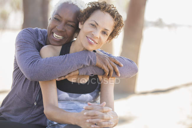 Усміхнені жінки обіймаються на відкритому повітрі — стокове фото