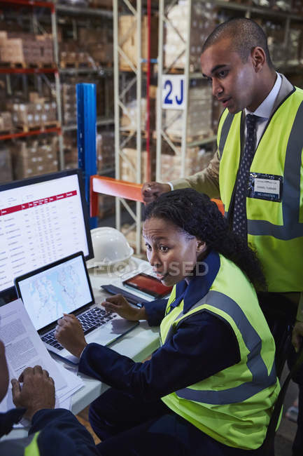 Managers meeting at laptop and computer in distribution warehouse — Stock Photo