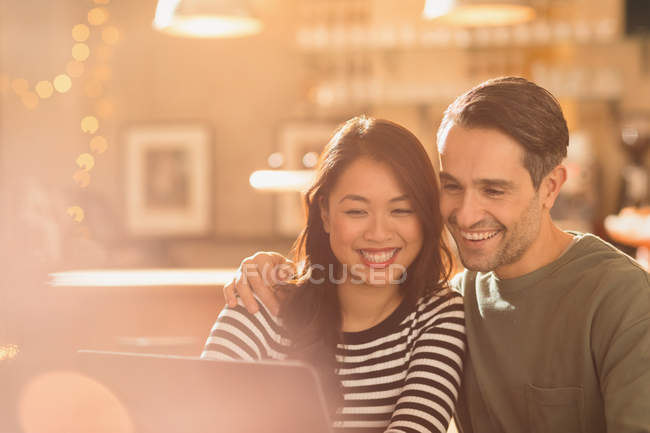 Sonriendo pareja de chat de vídeo en el ordenador portátil en la cafetería - foto de stock