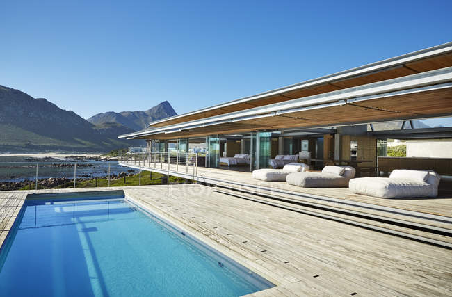 Modern luxury hotel swimming pool under sunny blue sky — Stock Photo