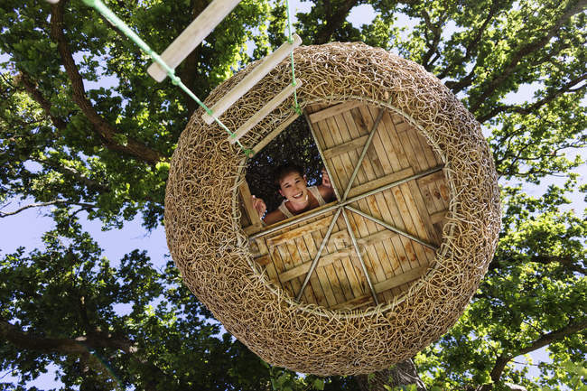 Donna sorridente nella casa sull'albero moderna — Foto stock