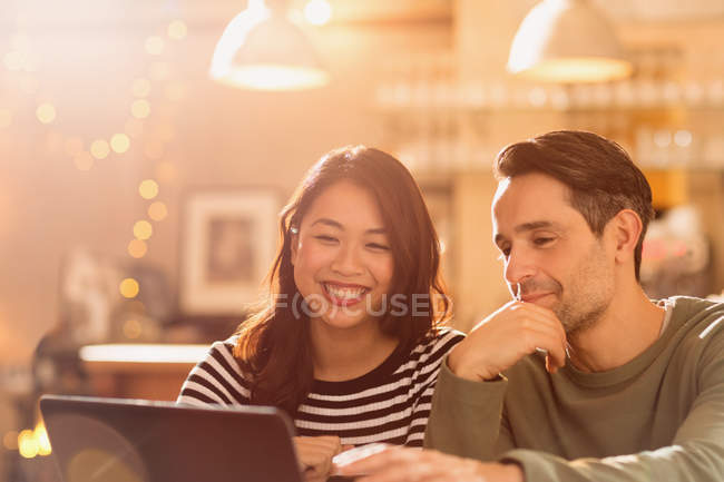 Sourire couple vidéo bavarder à l'ordinateur portable dans le café — Photo de stock