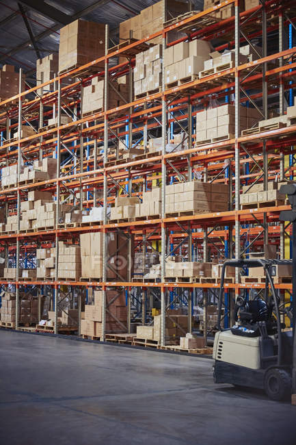 Mercadorias caixas de papelão empilhadas em prateleiras em armazém de distribuição — Fotografia de Stock