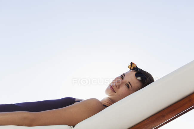 Frau liegt auf Liegestuhl im Freien — Stockfoto