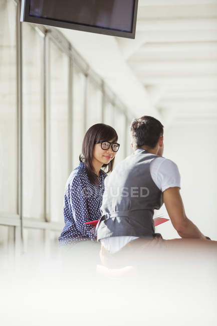 Бизнесмен и деловая женщина разговаривают в коридоре в современном офисе — стоковое фото