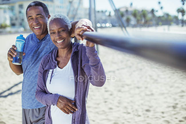 Retrato de casal sênior sorridente no parque infantil da praia — Fotografia de Stock