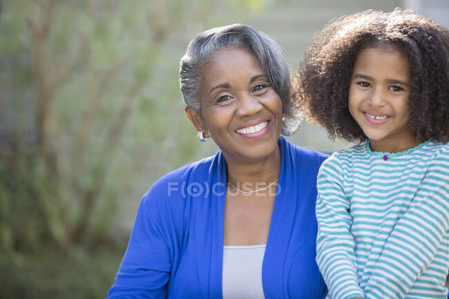 Portrait of smiling grandmother and granddaughter — Stock Photo