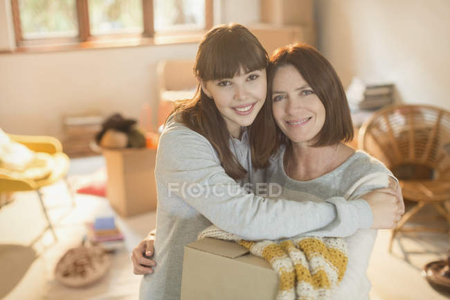 Ritratto madre sorridente aiutare giovane figlia adulta trasferirsi in un nuovo appartamento — Foto stock