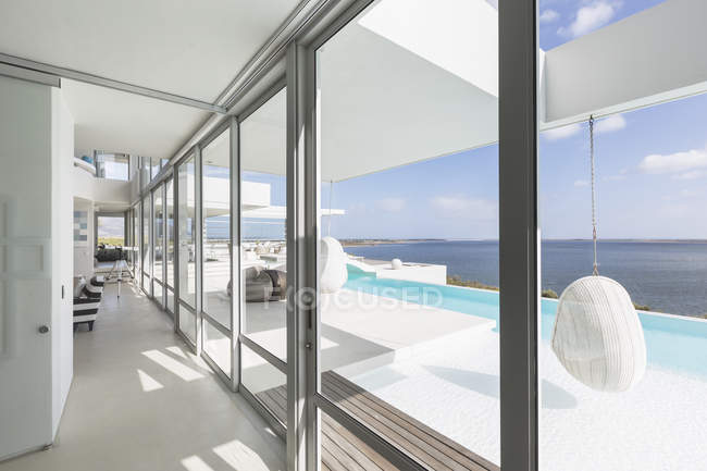 Janelas modernas de vitrine de luxo com piscina infinita e vista para o mar — Fotografia de Stock