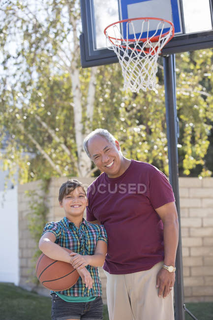 Portrait of grandfather and granddaughter playing basketball — Stock Photo