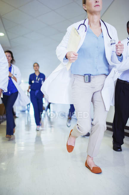 Doctor rushing down hospital hallway — Stock Photo