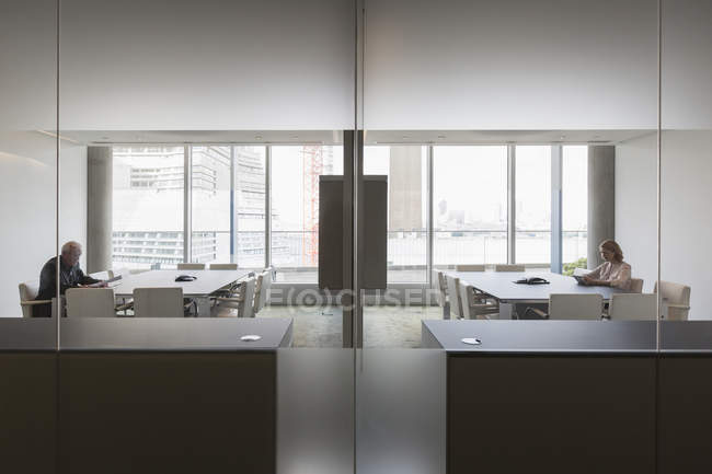 Geschäftsleute, die in modernen symmetrischen Konferenzräumen arbeiten — Stockfoto