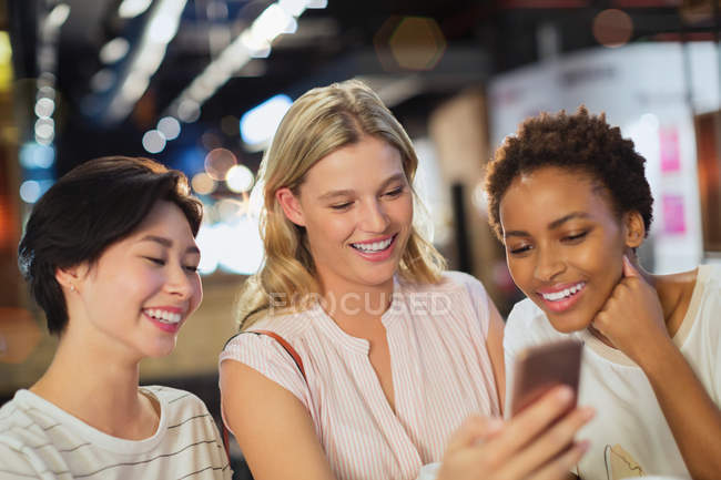 Sonrientes mujeres jóvenes tomando selfie en la tienda - foto de stock