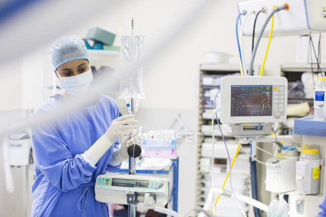 Enfermera de pie por equipos médicos y de monitoreo - foto de stock