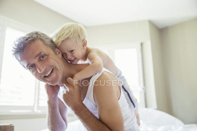 Vater trägt Sohn huckepack — Stockfoto