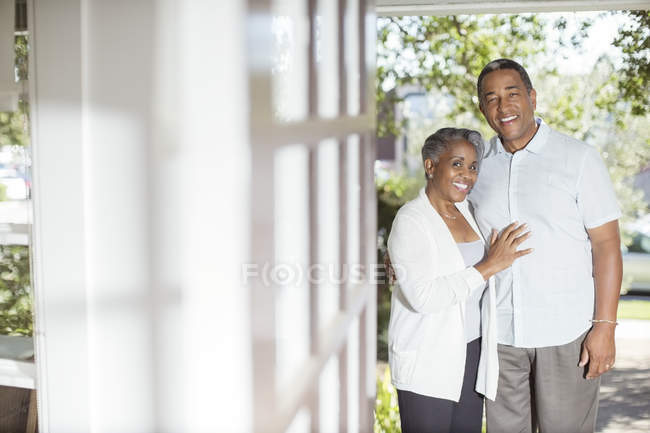 Retrato de pareja mayor sonriente en la puerta - foto de stock